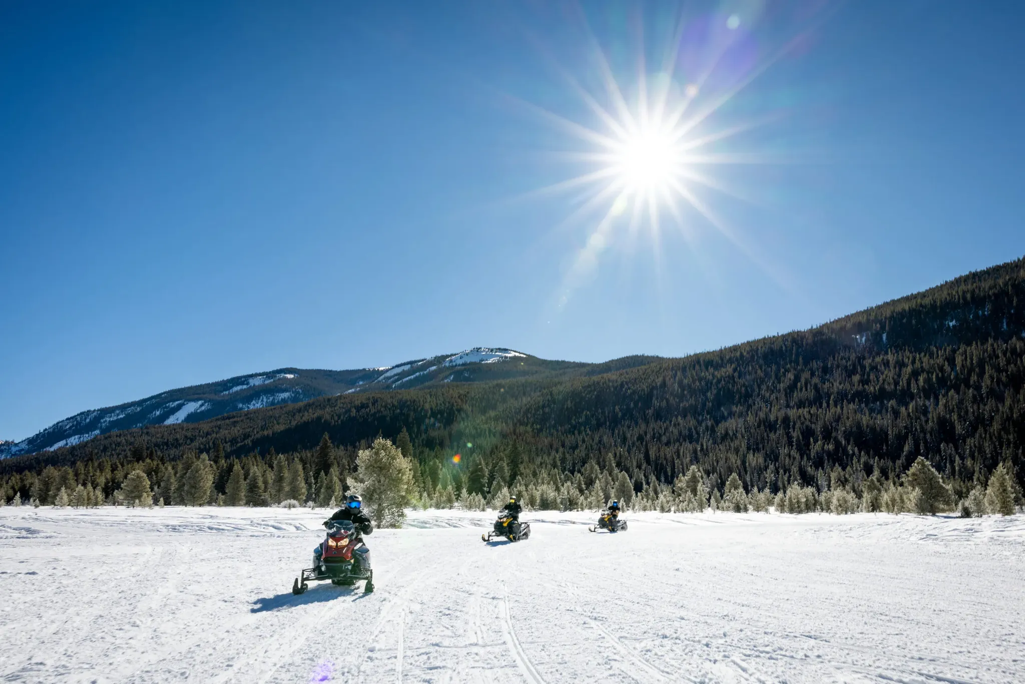 Three riders on a High Adventure guided snowmobile tour at Copper Mountain, Colorado.
